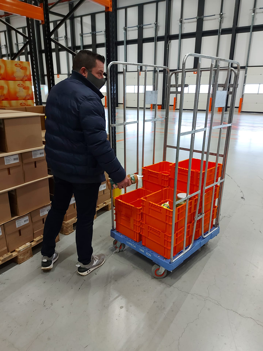 Draaistapelbakken in gebruik in het magazijn van Horeca Van Zon Man vult draaistapelbakken met producten in het magazijn